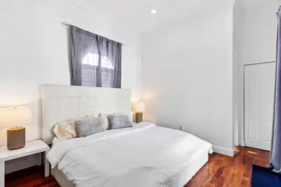 a white bedroom with a large white bed with two lamps at Luxurious 5BR and 3BA Lakefront Villa near Beach in Hollywood