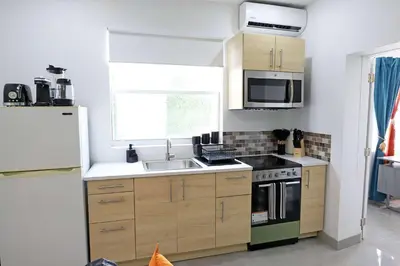 a kitchen with a sink and a stove and a refrigerator at Rooftop Retreat on Ocean Drive with Beach View in Miami Beach