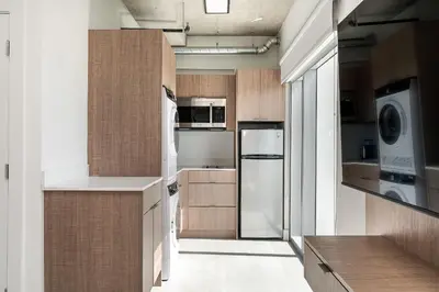 a kitchen with wooden cabinets and a refrigerator at Milan Aventura Hotel in Aventura