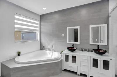 a bathroom with a tub and two sinks and a bath tub at 4 BR Designer Home Next to Shul and Community Pool villa in Fort Lauderdale