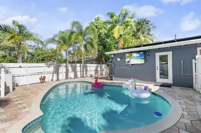 a swimming pool with a toy horse in a backyard at Chic Getaway Near Wilton Drive l Your Urban Escape in Fort Lauderdale