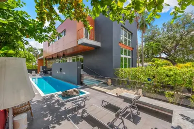 a home with a swimming pool and a house at Villa Nova in Miami