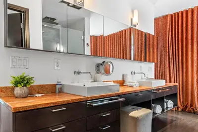a bathroom with two sinks and two mirrors at Villa Nova in Miami