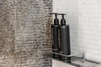 two black bottles on a shelf on a brick wall at Villa Nova in Miami