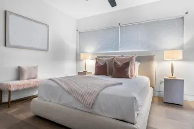 a white bedroom with a large bed with pillows at Villa Nova in Miami