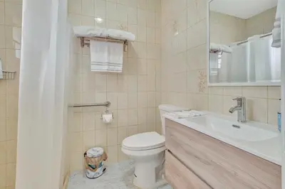 a white bathroom with a toilet and a sink at Dreams Studio in Hialeah