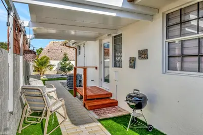 a patio with chairs and a grill on the side of a house at Dreams Studio in Hialeah