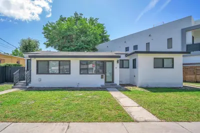a white house with a lawn in front of it at Villa Roads - Ideal Stay in Miami - King - Bed Parking - Near Airport, Brickell, Coconut Grove, Little Havana, Wynwood & Calle 8 in Miami