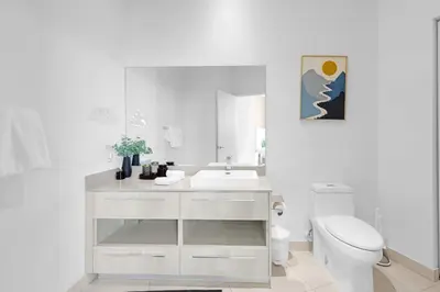 a white bathroom with a sink and a toilet at 2BR Ocean View Balcony & Pool in Hollywood