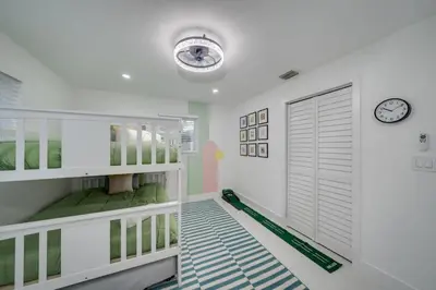 a childs room with a crib and a clock on the wall at Home with Games Pool Paradise in Fort Lauderdale