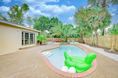 a pool with a toy dinosaur in a yard at Home with Games Pool Paradise in Fort Lauderdale