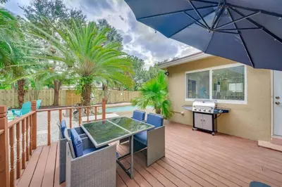 a patio with a table and chairs and an umbrella at Home with Games Pool Paradise in Fort Lauderdale