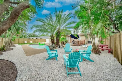 a patio with blue chairs and a pool at Home with Games Pool Paradise in Fort Lauderdale