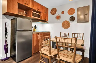 a kitchen with a table and a stainless steel refrigerator at Stylish Miami Suites with Self Check-in in Miami