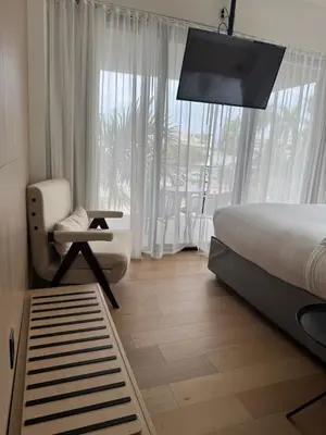 a bedroom with a bed and a chair and a window at The March Hotel in Miami Beach