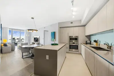 a kitchen and living room with a table and a counter at Beautiful Views From a Comfortable Condo with Beach Access! in Hollywood