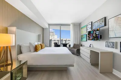 a bedroom with a bed and a desk and a window at Beautiful Views From a Comfortable Condo with Beach Access! in Hollywood