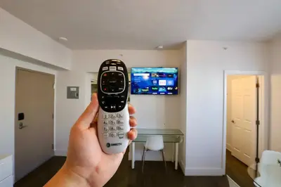 a person holding a remote control in a room at South of Fifth Studio Steps to Beach on Ocean Drive in Miami Beach