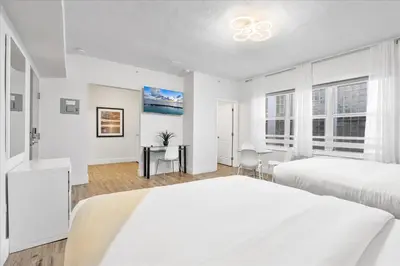 a white bedroom with two beds and a desk at South of Fifth Studio Steps to Beach on Ocean Drive in Miami Beach