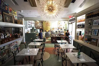 a restaurant with tables and chairs and a chandelier at South of Fifth Studio Steps to Beach on Ocean Drive in Miami Beach