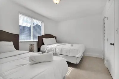 a white room with two beds and a window at Magical 2 BR Apartment 5 mins to Brickell Best Area in Miami in Miami