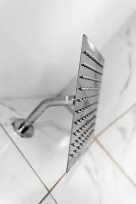 a metal shower head on a white tiled wall at Celeste House Enjoy Caribbean 2 BR APT in Miami