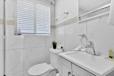 a white bathroom with a toilet and a sink at Celeste House Enjoy Caribbean 2 BR APT in Miami