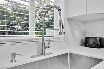 a white kitchen with a sink and a window at Celeste House Enjoy Caribbean 2 BR APT in Miami