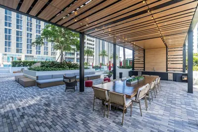a patio with a wooden table and chairs at Lux 2BD Apt with Stunning Water Views in Miami