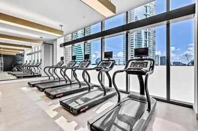 a row of treadmills in a gym with windows at Lux 2BD Apt with Stunning Water Views in Miami