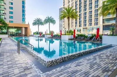a swimming pool with palm trees and buildings at Lux 2BD Apt with Stunning Water Views in Miami