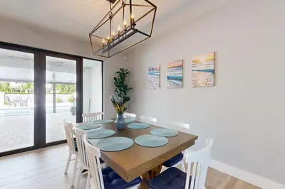 a dining room with a wooden table and white chairs at Outdoor Oasis! Group-Friendly Miami Getaway in Burrs Strip