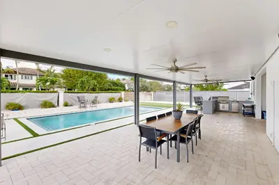 a living room with a table and chairs and a pool at Outdoor Oasis! Group-Friendly Miami Getaway in Burrs Strip