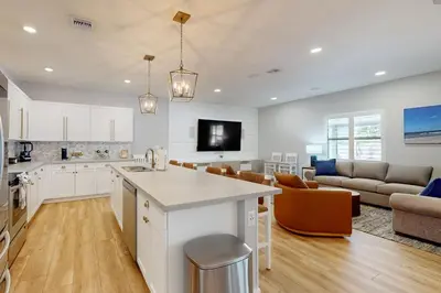 a kitchen and living room with white cabinets and a couch at Outdoor Oasis! Group-Friendly Miami Getaway in Burrs Strip