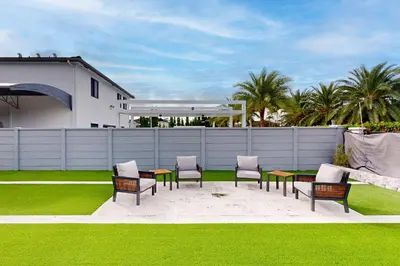 a patio with chairs and a table and a fence at Outdoor Oasis! Group-Friendly Miami Getaway in Burrs Strip
