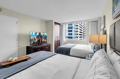 a hotel room with two beds and a flat screen tv at Gallery One Resort Access Fort Lauderdale Beach in Fort Lauderdale