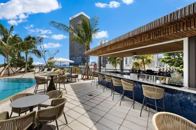 a patio with tables and chairs next to a swimming pool at PH 5107 Gale Luxury 1BR with Sea - Downtown Views in Miami