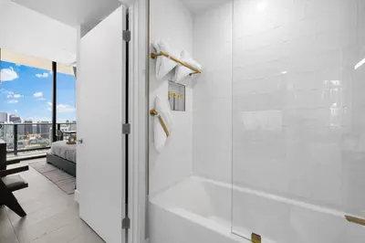 a white bathroom with a shower and a tub at PH 5107 Gale Luxury 1BR with Sea - Downtown Views in Miami