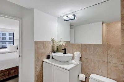 a white bathroom with a sink and a bed at Ocean View Serenity Condo Beach Service 915 in Miami Beach