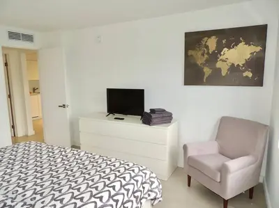 a bedroom with a bed and a chair and a tv at 2BR in Heart of SoBe with Parking in Miami Beach