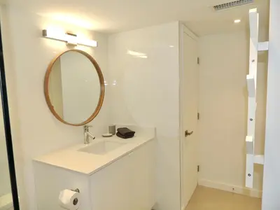 a white bathroom with a sink and a mirror at 2BR in Heart of SoBe with Parking in Miami Beach
