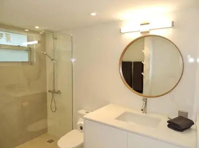 a bathroom with a sink and a mirror and a shower at 2BR in Heart of SoBe with Parking in Miami Beach