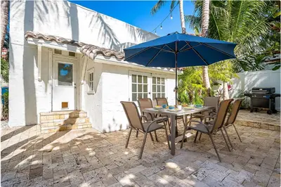 a table with chairs and an umbrella on a patio at Villa Treasure on the beach by The Gold Nests in Hollywood