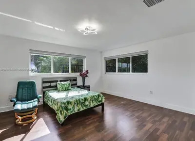 a bedroom with a bed and a chair at Casa Ocaso in Miami