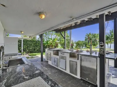 an outdoor kitchen with a view of a yard at Casa Ocaso in Miami