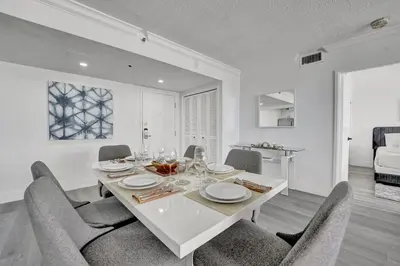 a dining room with a white table and chairs at Charming Ocean View Condo Beach Service 806 in Miami Beach