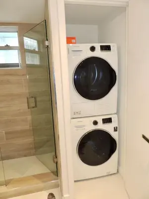 a washer and dryer in a bathroom with a shower at Lux design 2 bedroom unit sleep 4 in SoBe bst area in Miami Beach