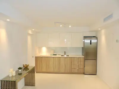 a kitchen with wooden cabinets and a stainless steel refrigerator at Lux design 2 bedroom unit sleep 4 in SoBe bst area in Miami Beach