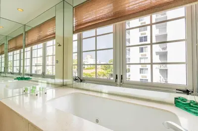 a large bathroom with two sinks and large windows at Luxury Large 1BR at The Carlyle SoBe Sleeps 4 in Miami Beach