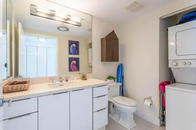 a white bathroom with a sink and a toilet at Luxury Large 1BR at The Carlyle SoBe Sleeps 4 in Miami Beach